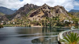 Presa de La Encantadora, rodeada de palmeras y vistas sobre Roque Blanco